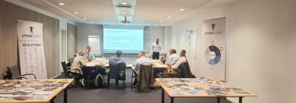 Billede af erfarne ledere, der studerer de 24 karakterstyrker for at mestre styrkebaseret ledelse.